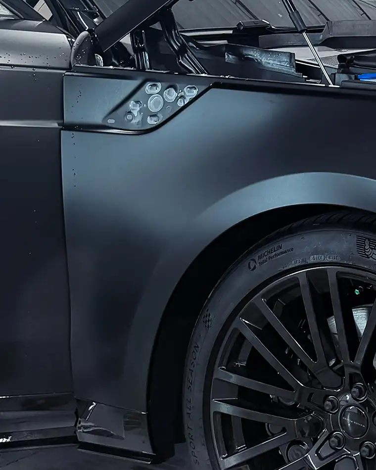 Paint protection film being installed on the hood of a luxury vehicle